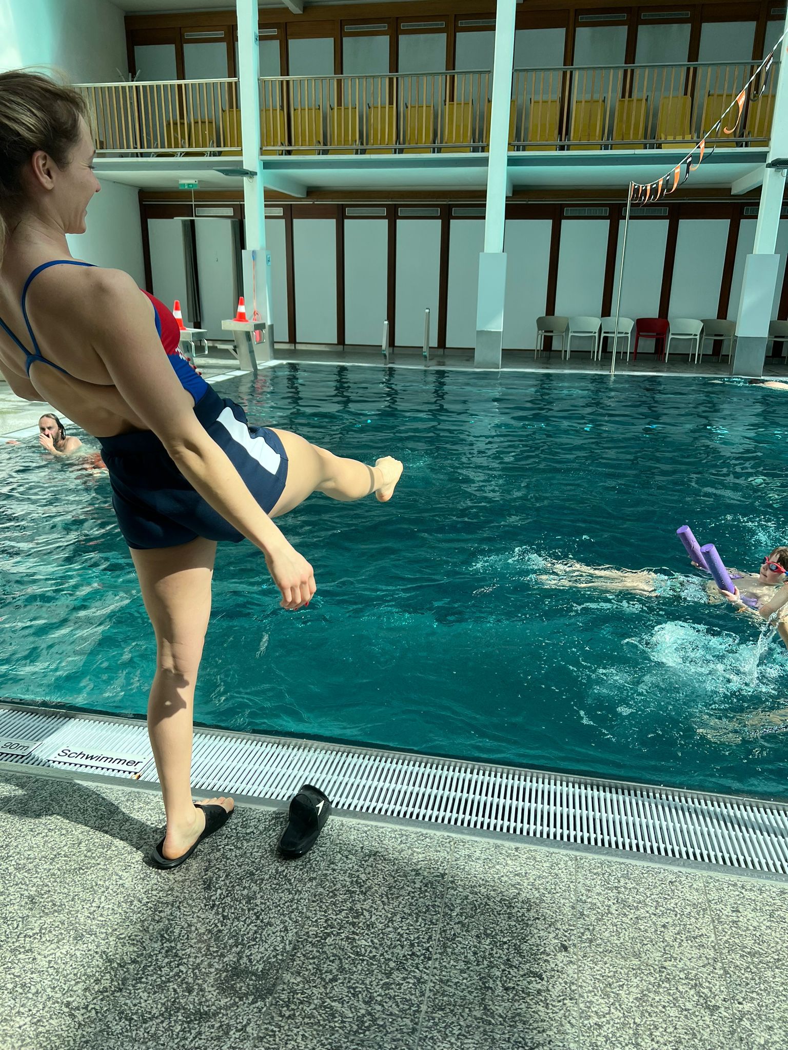 Sarah zeigt Kindern eine Schwimmübung